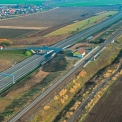 Pohled na trasu silnice R7 u zastávky ČD Droužkovice v km 10,320 ve směru na Prahu