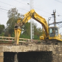 Pásové hydraulické rýpadlo Komatsu PC210NLC-8 rozbíjí starý železniční most.
