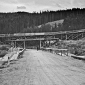 Rozestavěný dálniční most přes přeložku silnice z Černé Hory do obce Žernovník. Za ním provizorní dřevěný most pro stavební drážku. (1942)