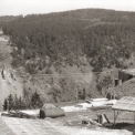 Fotografie z léta roku 1957 zachycuje původní opěru mostu na levém břehu Vltavy. Na pravém břehu Vltavy (v pozadí) je vidět dokončená opěra mostu a na ni navazující rozestavěná dálková silnice.