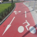 Cyklostezka s asfaltem podbarveným ve hmotě v barvě červené.