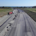 Srpen 2017 – pokládka ložné vrstvy asfaltu ACL na podkladní vrstvu asfaltu VMT na hlavní trase dálnice