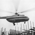 Obr. 1 – Historické foto z výstavby mostu – uložení spojovacích nosníků na hustou síť lešení pomocí vrtulníku