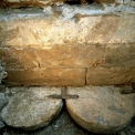 Obr. 7 – Špatně vytesané nebo opotřebované mlýnské kameny (průměr 1 m, tl. 0,25 m) položené po obvodě základu