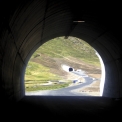 Pohled z tunelu Olafs do fjordu Hedinsfjord s budovanou silnicí a portálem tunelu Siglu